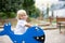 Cute toddler childplaying on the playground, rocking on blue fish swing