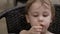 cute toddler is eating, closeup portrait, little girl or boy is chewing bun at home
