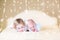 Cute toddler girl and her little newborn baby brother with warm soft lights