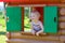 Cute toddler girl hiding in playhouse at playground