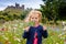 Cute toddler girl with Irish cloverleaf lollipop with Rock of Cashel castle on background. Happy healthy child on flower