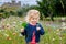 Cute toddler girl with Irish cloverleaf lollipop with Rock of Cashel castle on background. Happy healthy child on flower