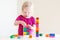 Cute toddler girl plaing with colorful blocks