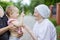 Cute toddler girl playing with her great grandmother. Cropped view of mother holding daughter