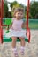 Cute toddler girl playing in sand on outdoor playground.