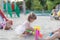 Cute toddler girl playing in sand on outdoor playground.