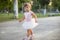 Cute toddler girl playing in sand on outdoor playground.