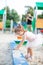 Cute toddler girl playing in sand on outdoor playground.