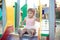 Cute toddler girl playing in sand on outdoor playground.