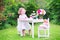 Cute toddler girl playing tea party with a doll