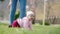 A cute toddler picks up and examines the pebbles while her mother changes her into other clothes. Children`s Day concept. Real tim