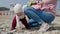 A cute toddler picks up and examines the pebbles while her mother changes her into other clothes. Children`s Day concept. Real tim