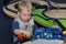 Cute toddler playing with a toy train in children center