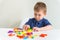 Cute toddler plays blocks toy. Little boy creates new design from bright plastic blocks. Copy space