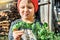 Cute toddler in red knitted hat holds fresh basil in hands