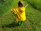 Cute toddler running on farm road with stick