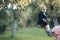 Cute toddler smile in suit, shirts, sneakers under tree, fashion