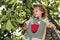 Cute toddler standing on a ladder and wearing cherries on his ears