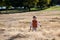 Cute toddler walking in the field of dry grass
