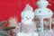 Cute toy smiling snowman, fir branches, tinsel and candlestick on a red background.