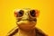 Cute turtle wearing sunglasses on yellow background