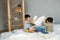 Cute tween boys playing with pillow on parents bed at home