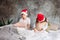 Cute tween children in Santa hats don`t want to wake up on bed with pillow in loft bedroom, christmas morning time