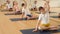 Cute tween girl sitting on mat in Padmasana yoga position with her hands clasped in prayer gesture above head while