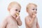 Cute twin boys toddler baby tasting lime slices.