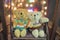 Cute two doll bears. Pair of cute teddies are sitting on wood swing with bokeh light in background. Teddies wear winter suite. Hug