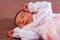 Cute two weeks old newborn baby girl wearing soft pink knit clothes