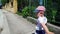 Cute Two Year Old Boy With Hat Walking on Street Sidewalk, Close Up