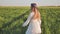 A cute Ukrainian girl running through a field at sunset.