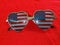 Cute USA Flag sunglasses laying on a red knit sweater - Showing Patriotism - Stars in your eyes