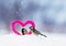 Cute Valentine card with a pair of birds next to a knitted decorative element pink heart stand in the snow in the Park