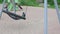 Cute view of  boy swinging on swing on playground on summer day.