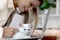 Cute white Persian cat sitting on laptop keyboard, owner woman working on computer with her happy fluffy comfortably pet, girl