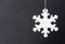 Cute white safety reflector in the form of snowflakes on black background. Necessary equipment to pedestrians for walks