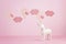 Cute white unicorn over the pink pastel background with clouds and baloons