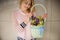 cute wicker basket with orchids and blue muscari in hands of young woman