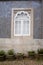 Cute window with traditonal Portugal tiles. Potted plants on the Cobblestone Road