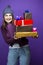 Cute Winsome Laughing Caucasian Adult Female in Seasonal Warm Clothing Posing with Big Wrapped Present Gift Boxes And Smiling