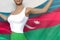 Cute woman in bright skirt holds Azerbaijan flag in hands behind her back on the white background - flag concept 3d illustration