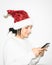 Cute woman in cosy christmas outft holds phone