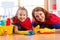 Cute woman and her kid daughter dressed like superheroes cleaning the floor and smiling