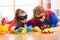 Cute woman and her kid daughter dressed like superheroes cleaning the floor and smiling