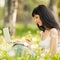 Cute woman with laptop in the park with dandelions