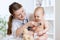 Cute woman pediatrician examining of baby kid with stethoscope