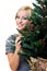 Cute woman smiling and holding a christmastree