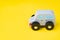 Cute wooden small toy car parking on vivid yellow background, car leasing, rental or insurance or automobile market concept